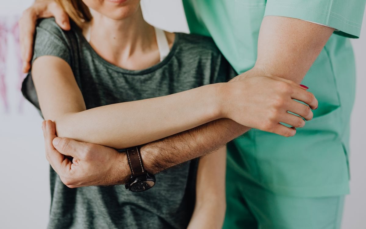 Physical therapist guiding a shoulder stretch